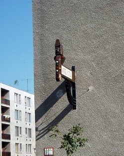 Kátai Mihály: A kecskeméti Hitel utca konzolos névtáblája 1977-ben, a ma már hiányzó kucsmás mellszoborral (fa, zománcozott vörösréz, 78x120 cm, archív felvétel, fotó: Kiss Béla)