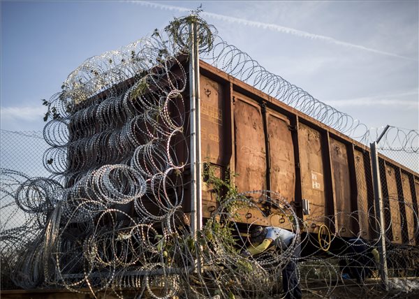 Horgos, 2015. szeptember 15. Szögesdrótot szerelnek fel a határzárként használt vasúti vagonra a magyar-szerb határnál, Röszke térségében 2015. szeptember 15-én. Ezen a napon hatályba léptek a migrációs helyzet miatti új szabályozások. MTI Fotó: Mohai Balázs